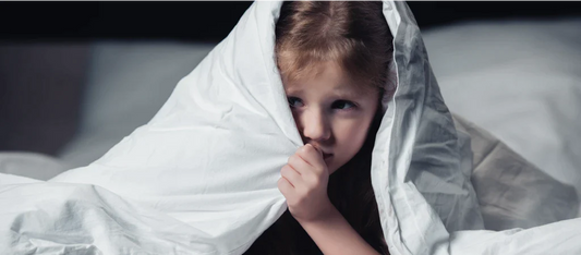 Child scared under a blanket.