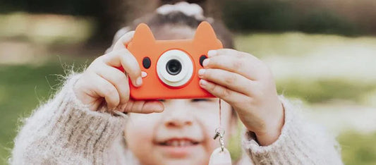 Child gleefully holding Akito the Fox camera. 