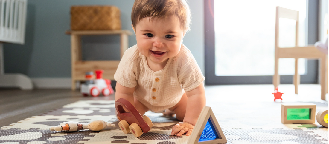 A baby crawling alongside favorite toys.