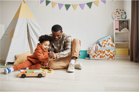 Father and child playing together with wooden toys in a playroom.