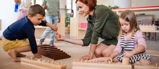 A teacher facilitating learning with two children and wooden toys.